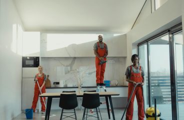 Team of professional cleaners working in a spacious, modern indoor setting.